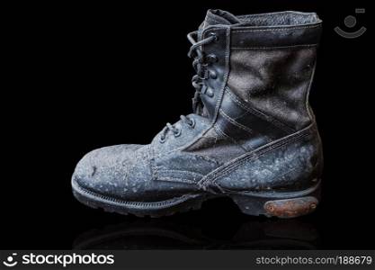 Old and dusty military boots on the black background.