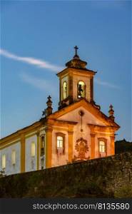 Old and historic 18th century church with its facade illuminated at dusk in the city of Ouro Preto, Minas Gerais, Brazil. Old and historic 18th century church with its facade illuminated at sunset