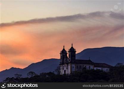 Old and historic 18th century church with its facade illuminated by sunset in the city of Ouro Preto, Minas Gerais, Brazil. Old and historic 18th century church with its facade illuminated by sunset