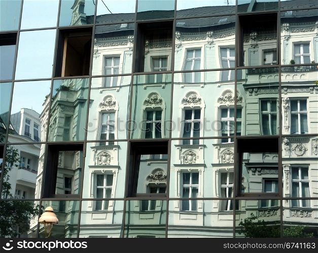 old and new- reflections. an old building is reflecting in the windows of a new one, Berlin, Germany