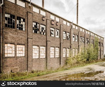 old and obsolete factory with weatherd walls and broken shattered windows