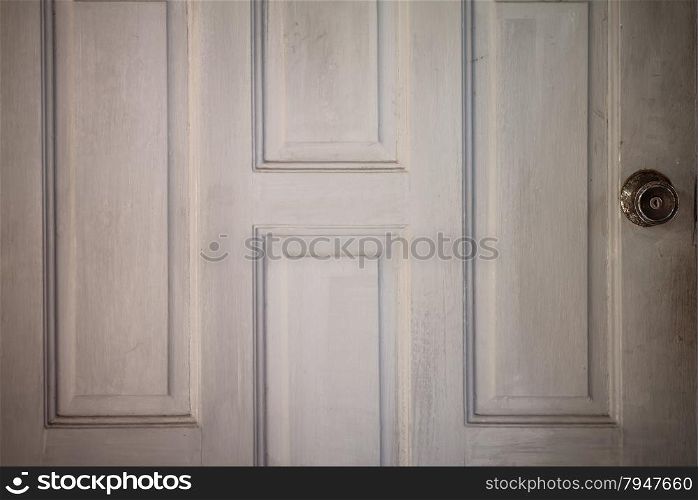 Old and rusty doorknob at the wooden door