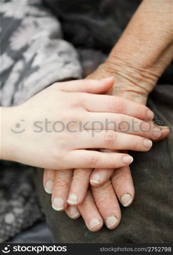 Old and young hands. Hands of the old woman - 84 years covered with young hands