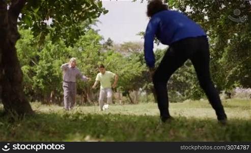 Old and young people, seniors and children, child and elderly persons. Sports fun, child playing football game with grandparents, soccer in park, happy old man kicking ball, recreation and leisure