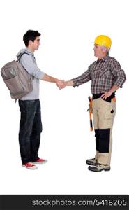Old and young student worker shaking hands