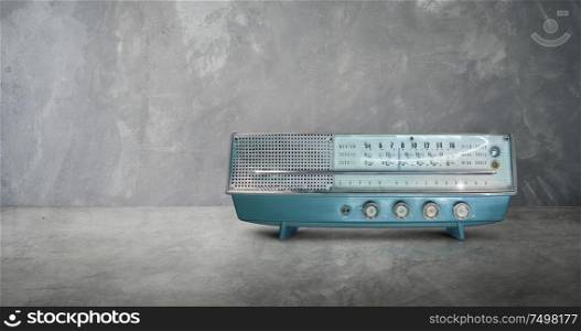 Old antique AM FM stereo radio isolated on cement wall and floor background .