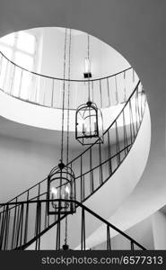 old antique spiral staircase leading upwards against the background of a glowing window