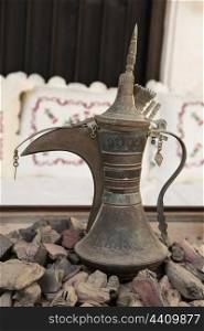 Old Arabic metal pitcher on hot coals. Old Arabic metal pitcher