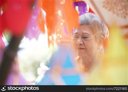 old asian elder elderly senior woman praying with paper lantern