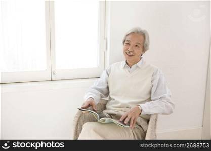 Old asian man reading a book