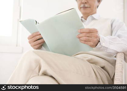 Old asian man reading a book