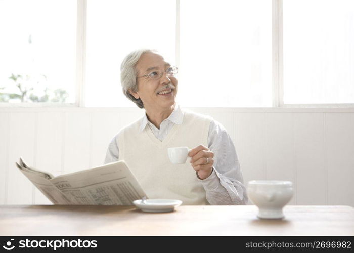Old asian man reading a newspaper