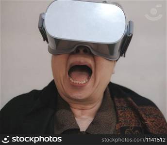 old asian senior woman wearing virtual reality goggles. VR headset device