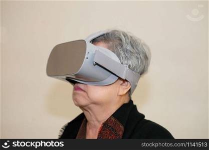 old asian senior woman wearing virtual reality goggles. VR headset device