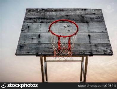 Old backboard basketball hoop on sky sunset background