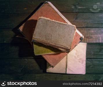 old badly shabby books lying on a dark wooden background. Old Book Wooden