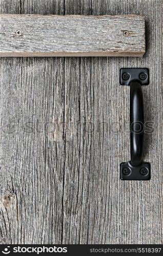 Old barn wood door. Distressed rustic barn wood door with handle as textured background