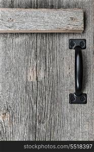 Old barn wood door. Distressed rustic barn wood door with handle as textured background