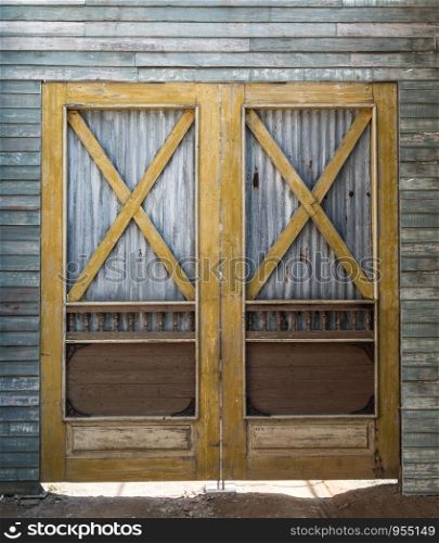 Old barn wooden bracing frame with zinc sheet double door.