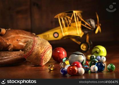 Old baseball and glove with antique toys on wood floor
