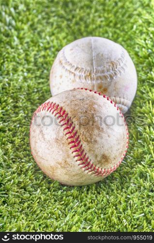 Old baseballs over synthetic grass, vertical HDR image