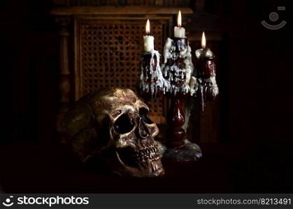 Old battered skull lies with an antique wooden candlestick. The concept of black magic, services from sorcerers and magicians. Old battered skull lies with an antique wooden candlestick