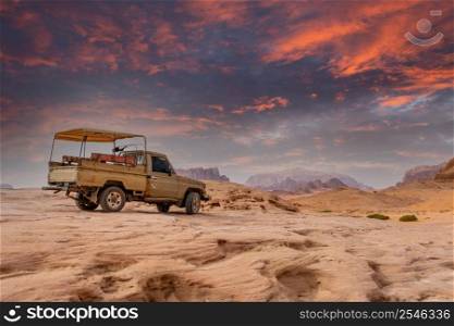 Old bedouin car with sandstones sunset landscape of Wadi Rum desert, Jordan