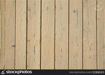 Old beige painted wooden fence close up.