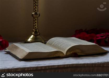 Old bible open on altar with candlestick