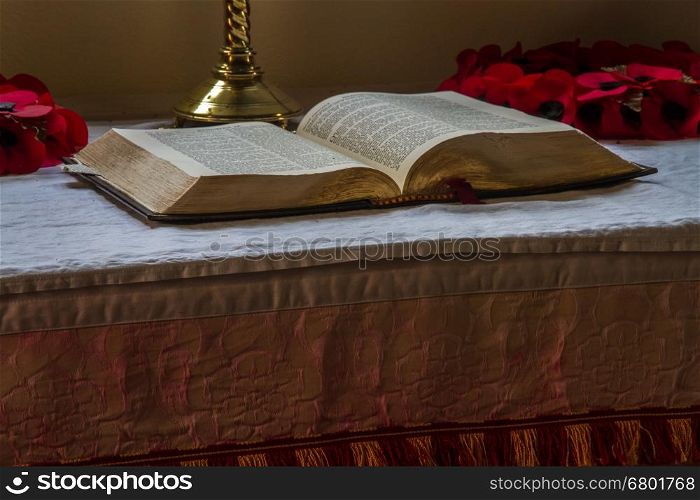 Old bible open on altar with candlestick