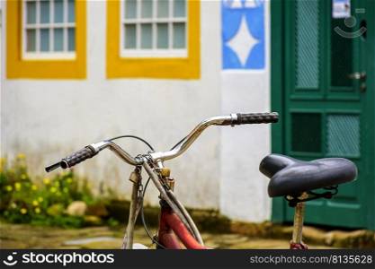 Old bicycle stopped in front of the colonial style houses of the historic city of Paraty on the south coast of Rio de Janeiro. Old bicycle stopped in front of the colonial style houses