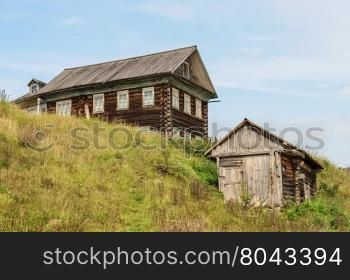 Old big log house and a shed in russian village, Vologda region. Summer day