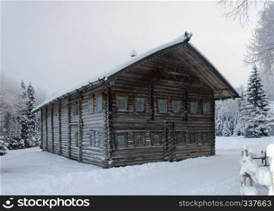 Old big wooden peasant house covered with snow. Village Malye Korely near Arkhanglesk, Russia. Winter time.