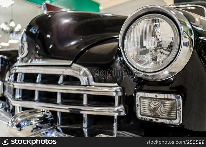 Old black car close up with grille and headlamp on exhibition