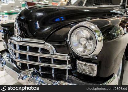 Old black car close up with grille and headlamp on exhibition