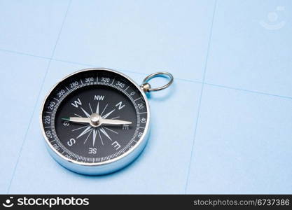 old black compass on blue paper background