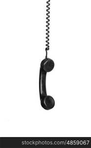 Old black phone hanging of a cable isolated on a white background