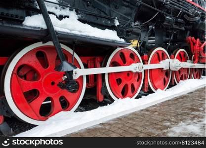 Old black steam locomotive wheels on railway track closeup