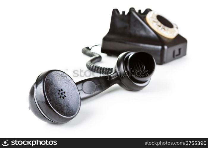 Old black telephone with rotary dial. Focus on handset in foreground. Isolated on white