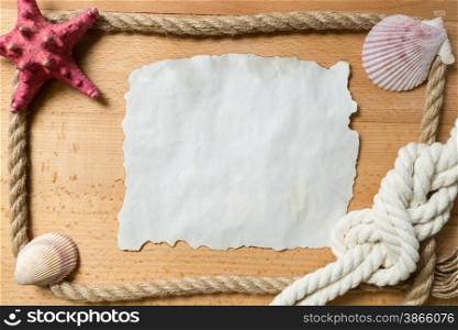 Old blank piece of paper with frame of ropes and seashells