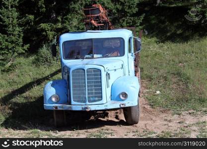 Old blue truck near the forest