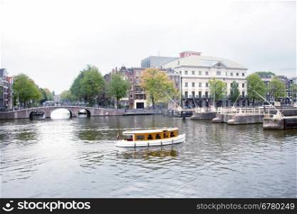 old boat on river Amstel near theater Carre in Amsterdam