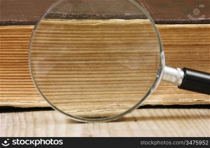 old book and magnifying glass