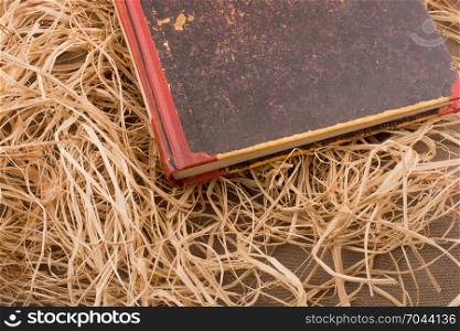 Old book placed on a straw background