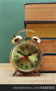 old books and alarm clock