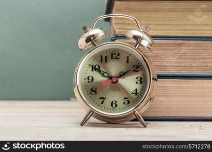 old books and alarm clock