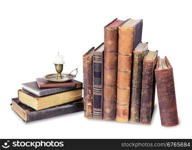 Old books and candle in a candlestick on a white background