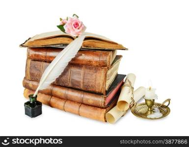 Old books, burning candle in candlestick, white feather in inkpot, rose flower and scroll with stamp, isolated on white background