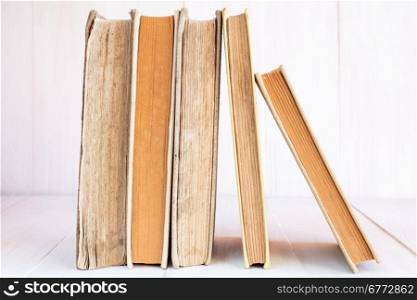 Old books in a row on wooden background