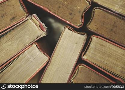 Old books on a wooden floor top view / hardback book piles in the library room for business and education background , back to school concept